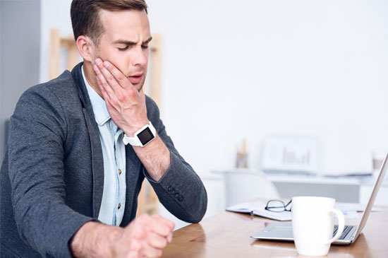 Man holding jaw in pain Man holding jaw in pain